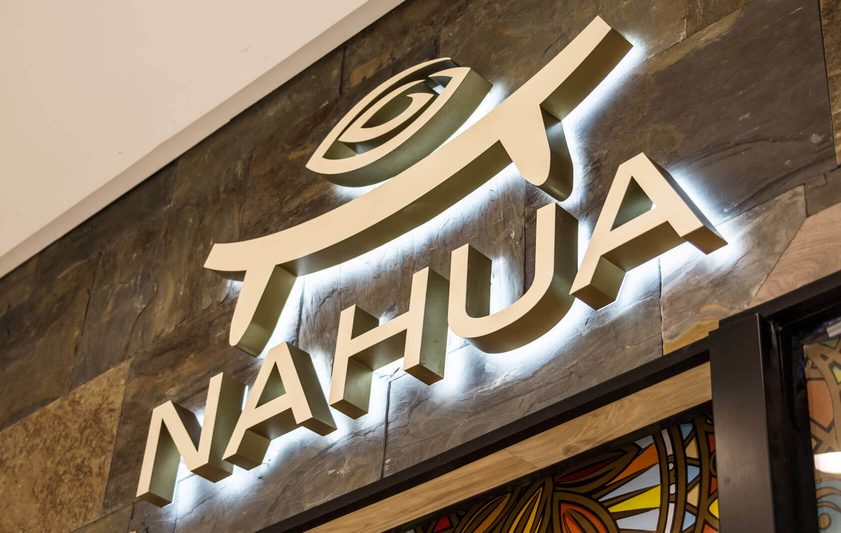 Nahua - LED light letters placed on the wall, visible halo effect